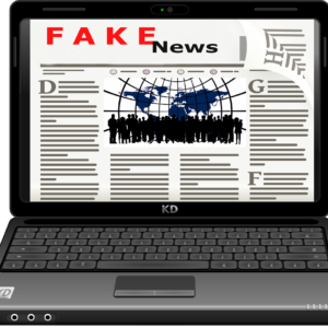 Em desenho um notebook preto, em que na tela apresenta um jornal com o título Fake News.